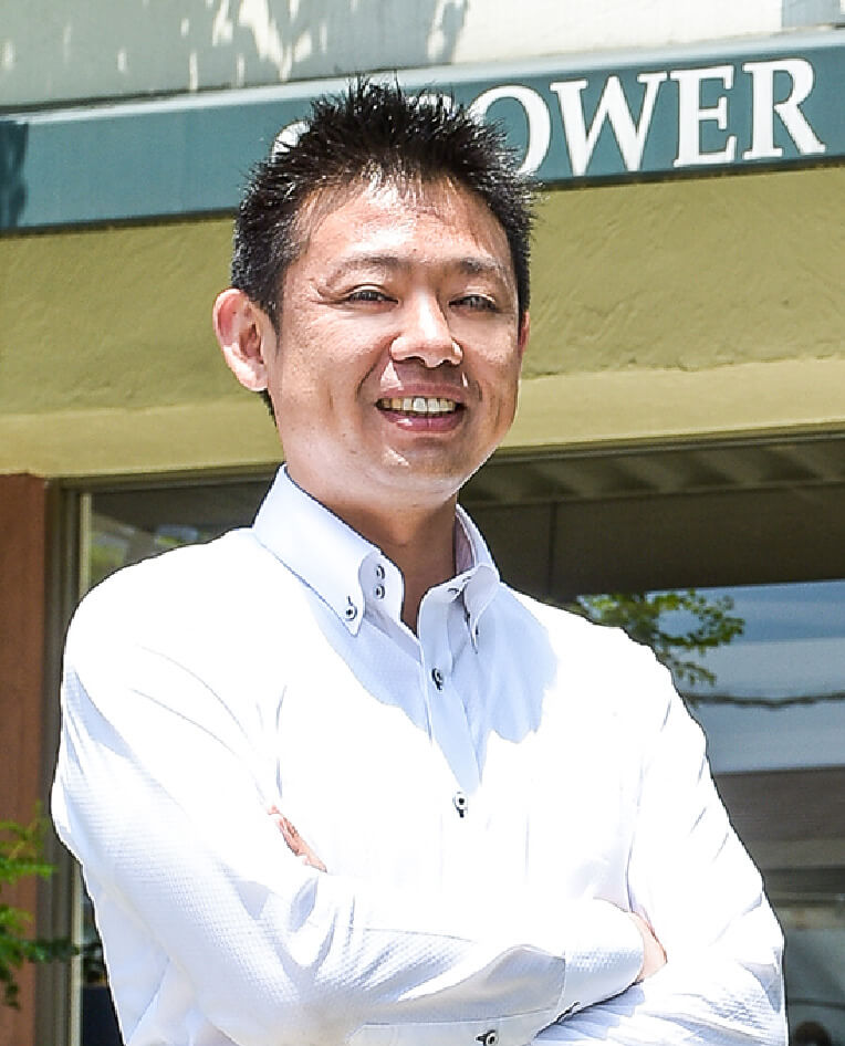 パワーハウス株式会社 代表取締役社長 井村 優介が腕を組んで笑っている写真